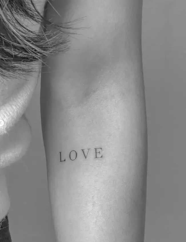 LOVE text tattoo in minimalist capitals by Chelsea.Q at Omnia Tattoo Studio